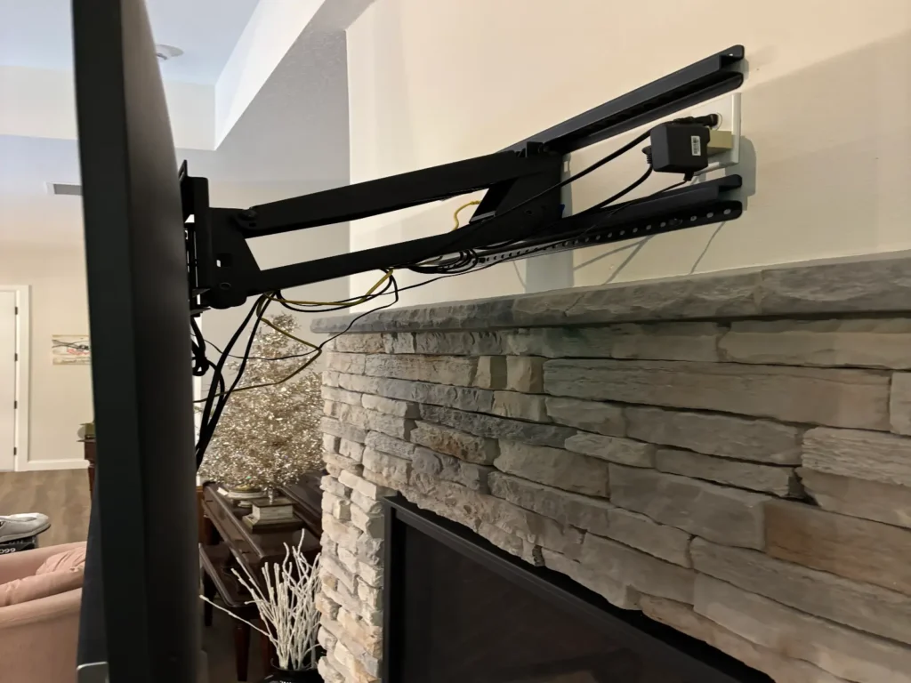 Pull down TV mount arm installed above stone fireplace in Ocala Florida