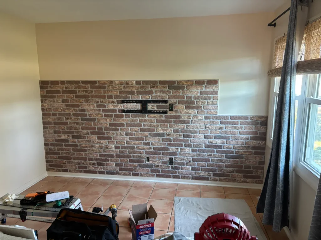 TV wall mount bracket installed on brick accent wall with cable outlets in Dunnellon Florida