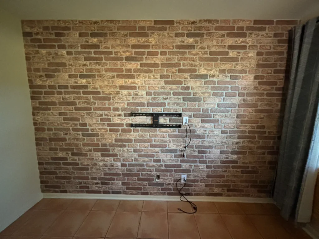 TV wall mount preparation with power and cable routing on brick accent wall in Summerfield Florida