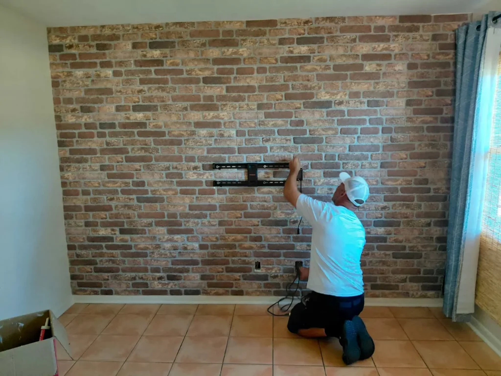 TV wall mount installation on brick accent wall with cable concealment in Ocala Florida
