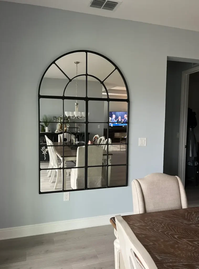 Large arched mirror professionally mounted in dining room in The Villages Florida