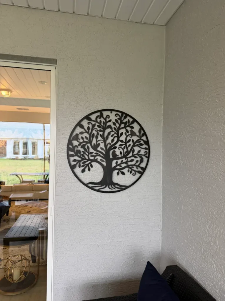 Outdoor metal tree wall art mounted on stucco wall in Ocala Florida