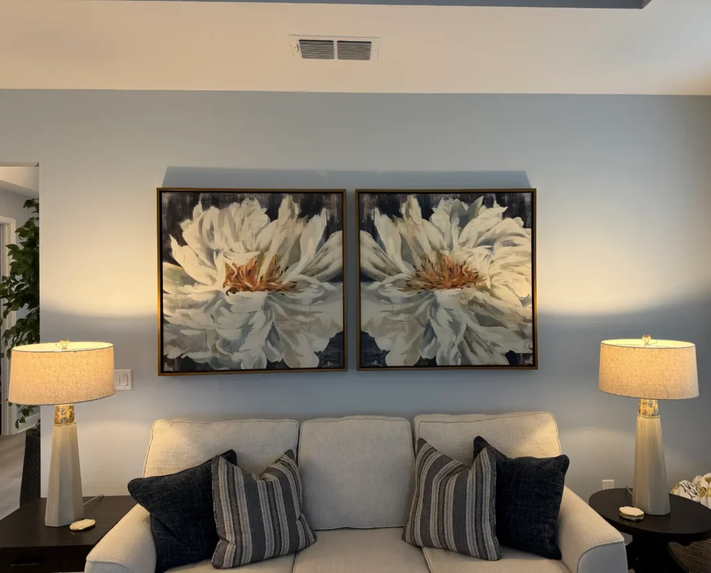 Matching floral canvas artwork aligned and professionally hung above sofa in The Villages Florida