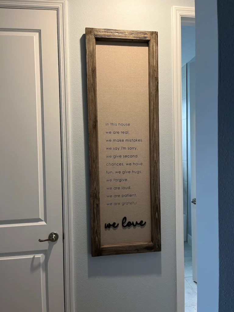 Tall farmhouse wall sign professionally installed between hallway doors in Ocala Florida