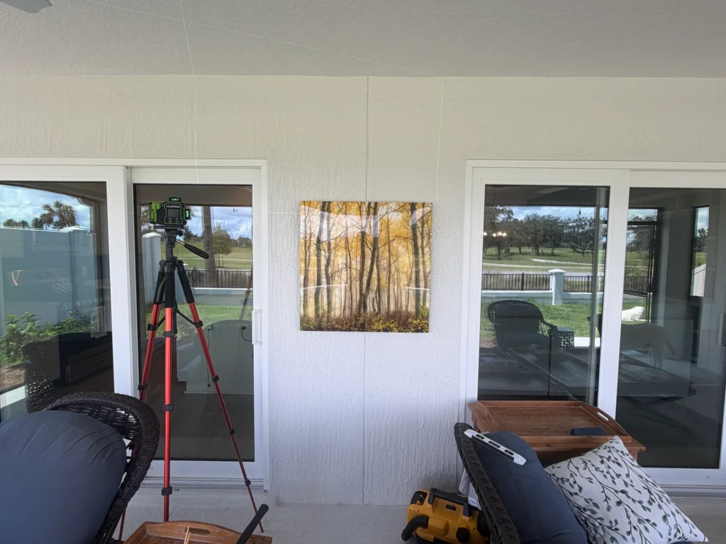 Decorative artwork professionally installed on an outdoor lanai wall using precision laser leveling in Ocala, Florida.